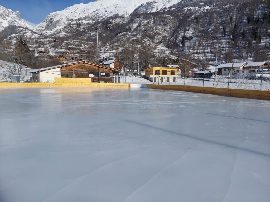 Eisplatz mit Bergponorama bei Tag