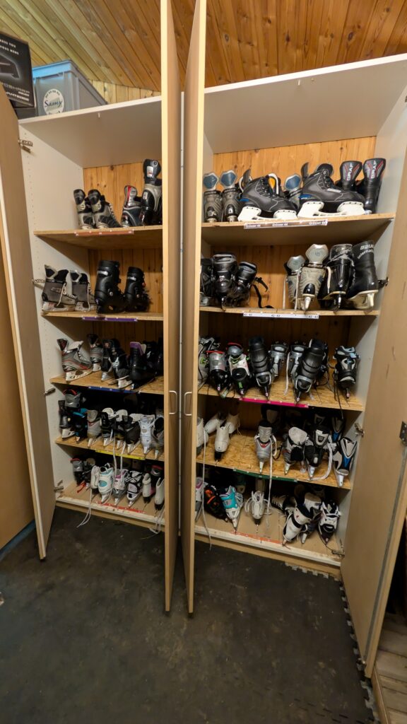Regale mit verschiedenen Schlittschuhgrössen zur kostenlosen Ausleihe bei der Natureisbahn Inschiischbahn Fieschertal